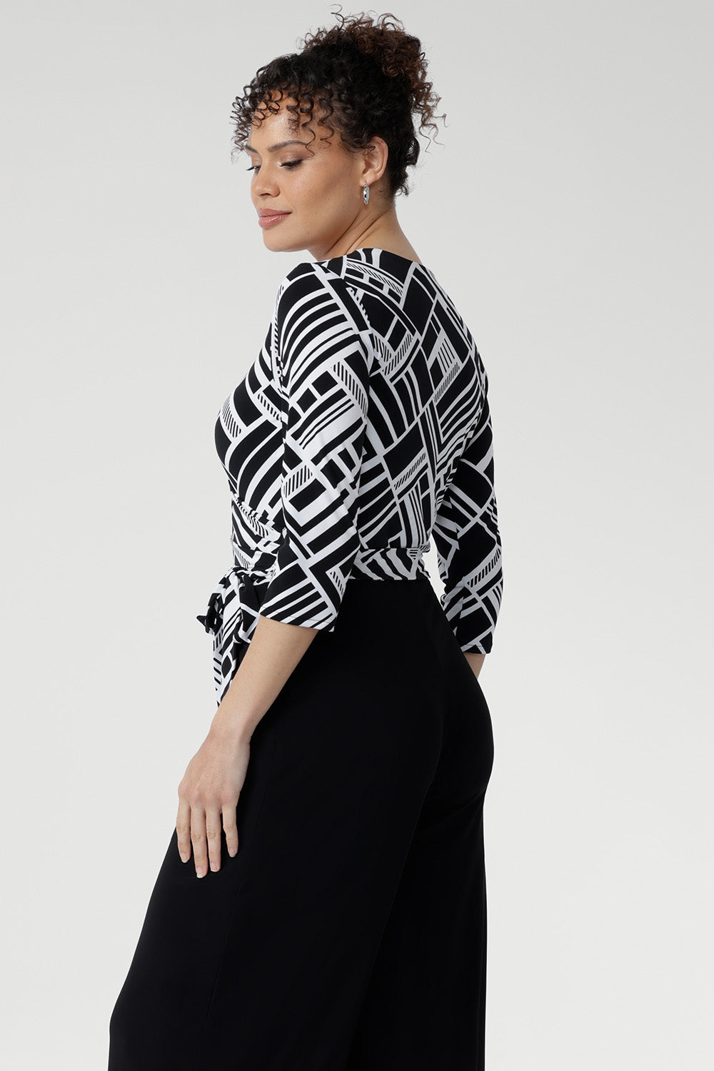 The contrast black jersey pants fall to a full length with a sleek straight leg and include functional side pockets, blending elegance with everyday ease. 