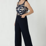 Effortless sleeveless women’s top featuring a clean square neckline, flattering bust darts and a longer back hem for comfortable everyday styling.