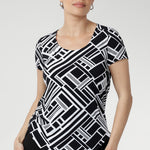Designed with a flattering fitted silhouette, this versatile top features a classic round neckline, short sleeves, and a curved shirttail hemline that adds a modern touch to any outfit. Available in sizes 8-24