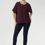 Effortlessly stylish and endlessly versatile, the Scout Tee in Plum is the perfect pairing for your everyday wardrobe. Worn here by a size 10 woman with charcoal-coloured pants, this look captures relaxed elegance with a modern edge.