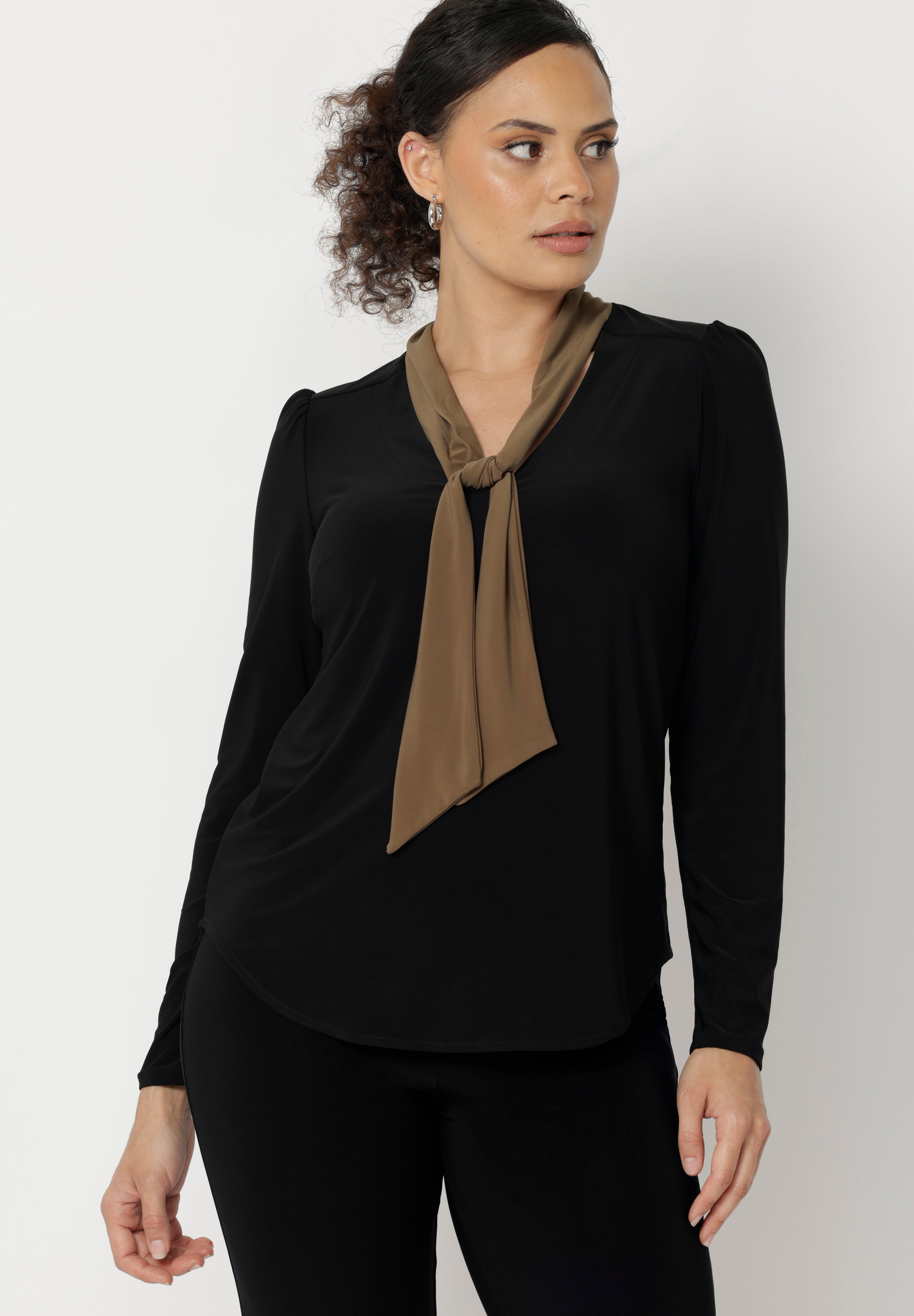 The Thom Top is a refined yet versatile addition to any wardrobe, blending elevated design with everyday ease. This elegant black long-sleeve top features soft coffee-coloured neck ties, offering flexible styling options to suit your day—tie them neatly for a polished office look or leave them open for a more relaxed, event-ready feel.