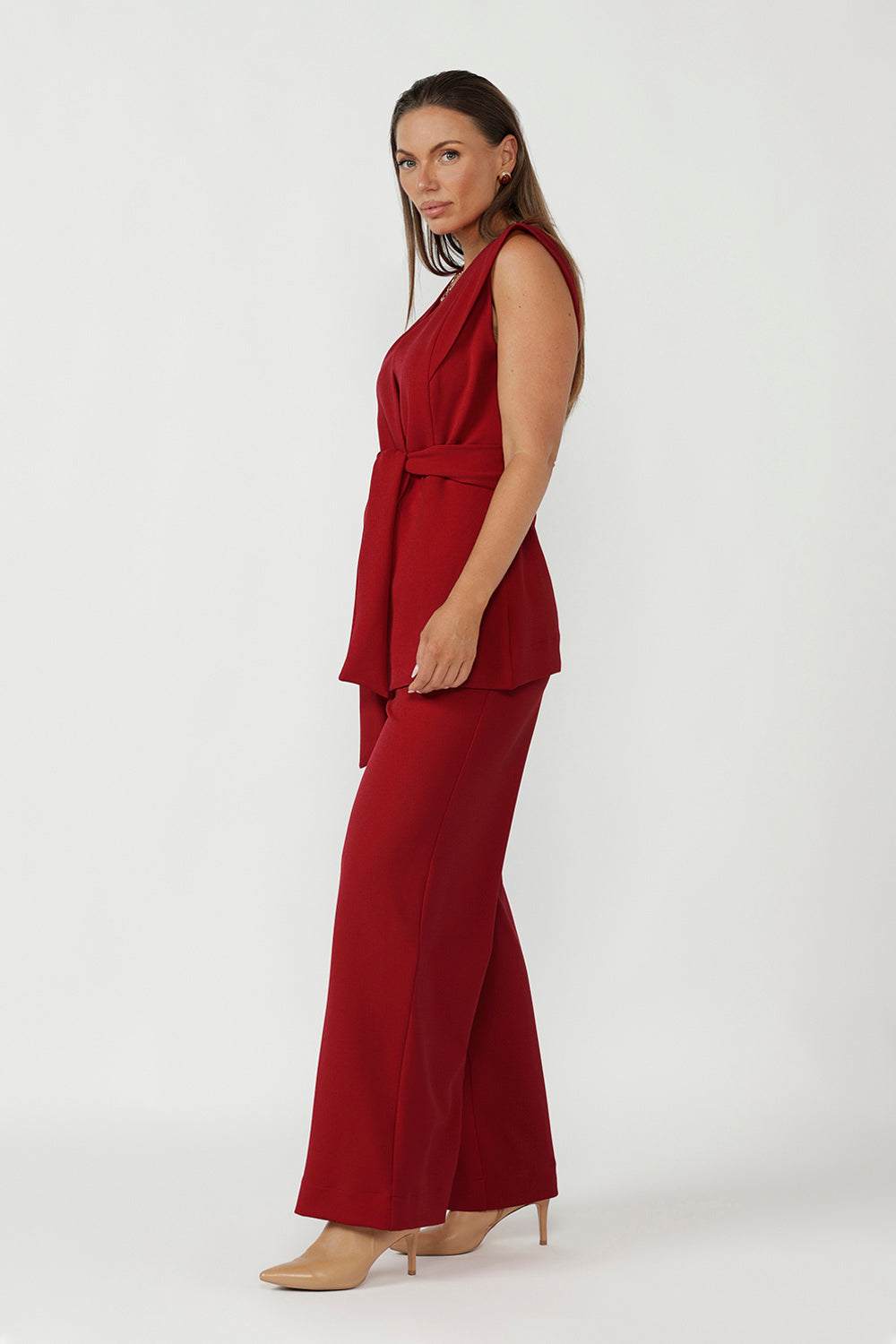 Australian-made women’s vest in flame red scuba jersey with tailored silhouette and waist-defining belt.