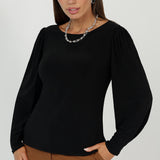 The Zara Top in Black is a versatile staple in women’s workwear Australia, crafted from dry-touch stretch jersey for all-day comfort. Featuring a flattering boat neckline and statement bellow sleeves, it’s perfect for polished office wear and effortless weekend styling in sizes 8–24.